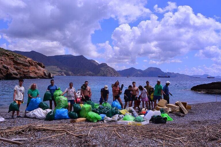 Un camión de basura, y agua milagrosa de Fátima, resultado de la limpieza de Cala Salitrona